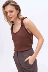 Musculosa de punto azul marino con brillo de lurex, escote redondo y breteles anchos decorados con rulos tejidos.
