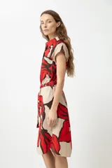 Vestido camisero color beige con estampado abstracto de flores rojas y marrones, de manga corta y largo a la rodilla. Incluye cinturón de la misma tela.