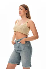 Top crop tejido al crochet color dorado, con breteles finos y terminación con flecos.