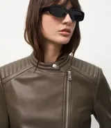 Campera biker de poliuretano color verde oliva, con cierre frontal asimétrico, bolsillos laterales con cremallera y detalle capitoneado en los hombros.