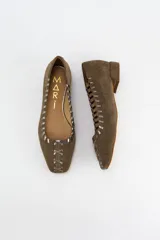 Mocasines de gamuza negra con detalle de costuras cruzadas en tono bronce a lo largo del borde y en la puntera. Poseen un taco bajo cuadrado de 2 cm.