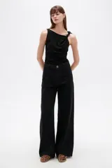 Pantalón jean negro de tiro alto y corte ancho.