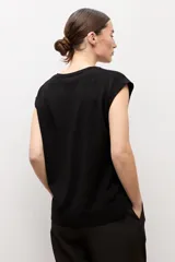 Chaleco de punto negro con escote en V y sisa amplia.