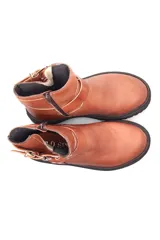 Botín de cuero color bordó con suela track negra, caña baja, puntera redondeada y ajuste con hebillas y arnés metálico.