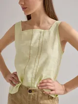 Top verde claro de lino con escote cuadrado, tirantes anchos y detalles de pespuntes verticales en el frente. La espalda es de algodón con spandex.