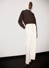 Jersey de punto grueso marrón con cuello redondo, diseño oversize y manga larga.