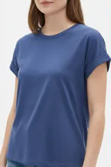 Remera de algodón color azul, de corte holgado, cuello redondo y mangas cortas con vuelta.