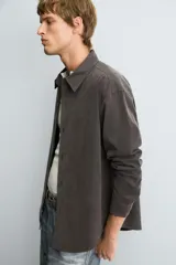 Camisa de corte relajado confeccionada en tejido fluido con mezcla de lyocell. Presenta cuello solapa, manga larga, cierre frontal con botones y un acabado con efecto lavado.