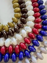 Collar de cuentas redondas y aplanadas con efecto marmolado en tonos grisáceos, con cierre metálico dorado.