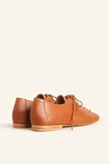 Zapato tipo oxford plano de cuero vacuno en color azul marino, con cordones al tono y suela de cuero.