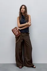 Pantalón wide leg de tiro alto, confeccionado en tela ligera de caída fluida y brillo sutil.