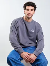 Buzo de cuello redondo Volcom de color gris oscuro, con diseño liso y pequeño logo estampado en el pecho. Cuenta con mangas largas y puños elastizados.