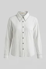 Camisa de manga larga color blanco, con cuello clásico, cierre frontal con botones marrones y costuras pespunteadas en contraste.