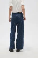 Pantalón de jean azul oscuro de corte ancho, con tiro alto, pinzas frontales y estampado de lunares.