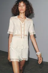 Shorts de tiro medio color crudo, confeccionados en hilatura de algodón con detalle de aplicación de crochet.