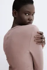 Remera de manga larga color marrón topo, de tejido liso y corte entallado, con cuello redondo.