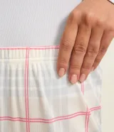 Conjunto de pijama largo de poliéster y elastano. Incluye una blusa celeste de manga larga con botones en el cuello y un pantalón de corte recto con estampado de cuadros en tonos blanco, rosa y gris.