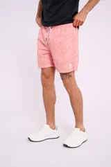 Short de baño color salmón con estampado de estrellas de mar blancas, cordón ajustable en la cintura y bolsillos laterales.