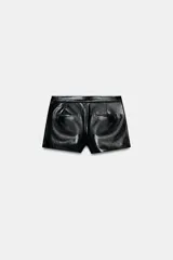 Shorts de tiro bajo confeccionados en material sintético con acabado efecto piel, cuentan con bolsillos delanteros y cierre frontal con cremallera y gancho metálico.