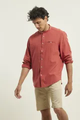 Camisa de cuello mao y manga larga, confeccionada en una mezcla de lino y algodón. Presenta un diseño de corte recto con botones en tono natural y un bolsillo pequeño en el pecho.