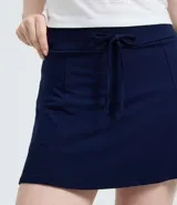 Short pollera de corte evasé confeccionado en viscosa, con cintura ancha y lazo ajustable en el frente.