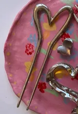 Pinza plateada para el pelo con detalle en forma de corazón.