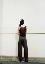 Pantalón de vestir marrón de tiro medio y corte recto, confeccionado en mezcla de algodón y poliéster. Presenta trabillas, cierre con hebilla y un diseño superpuesto en la cintura que aporta un detalle único y sofisticado.