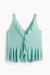 Musculosa de color verde menta en punto liviano, con breteles anchos, escote en V pronunciado y volados decorativos en el escote y el ruedo de doble capa.
