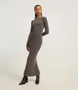 Vestido midi color gris topo, confeccionado en tejido rib de algodón y elastano. Posee cuello redondo, manga larga, drapeado lateral y abertura trasera.