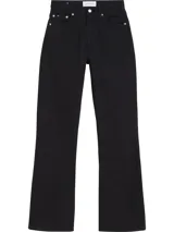 Jean de mujer Calvin Klein Jeans, color negro, tiro alto, estilo bootcut (pierna recta con ligera apertura en el bajo) y confeccionado en denim de algodón con un pequeño porcentaje de elastano. Presenta diseño clásico de cinco bolsillos y cierre frontal con botones.