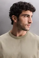 Camiseta de corte relajado confeccionada en tejido de algodón pesado, con cuello redondo y manga corta.