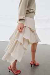 Falda midi de tiro alto, color marrón oscuro, con múltiples capas de volantes y bajo asimétrico.