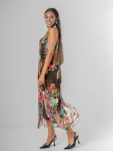 Vestido largo tipo musculosa confeccionado en seda italiana, con diseño de flores abstractas en tonos saturados y nudo regulable en el hombro.