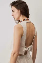Blusa cropped color chocolate, de silueta suelta y cuello redondo, con terminación de bordes deshilachados.