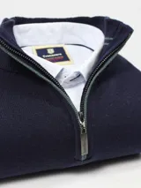 Sweater azul marino de hilo con medio cierre frontal con cremallera y detalles en rojo en cuello y puños.