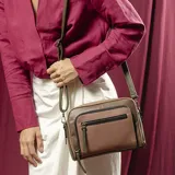 Cartera bandolera de diseño tricolor en tonos amarillo, marrón y negro, con múltiples compartimentos frontales con cierre y correa larga regulable y desmontable.