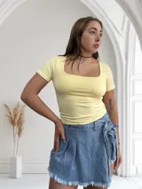 Remera negra ajustada al cuerpo, con escote cuadrado y mangas cortas.