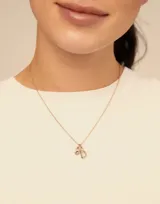 Charm de metal con baño de oro y cristal azul engastado en el centro, diseñado con una forma redonda y argolla superior para colgar.