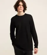 Remera negra de algodón de manga larga con cuello redondo y puños ajustados.