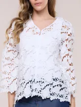 Chaqueta de encaje calado blanco, con escote en V, frente abierto y mangas 3/4 acampanadas con terminación festonada.