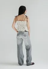 Pantalón de jean recto de tiro medio color gris oscuro con costuras verticales.