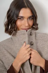 Campera de paño de lana color marrón con diseño oversize. Presenta cuello alto, cierre frontal con botones y detalles en pana azul marino en los puños y en las tapas de los bolsillos frontales.