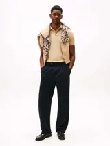 Chomba color arena de Tommy Hilfiger Sport, confeccionada en piqué de mezcla de algodón elástico con tecnología Flex, que absorbe la humedad y es antiolor. Tiene corte regular, cuello de chomba, cartera de dos botones y logo de la marca bordado en el pecho.