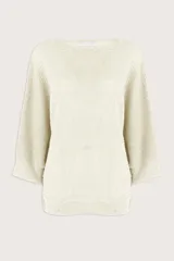 Suéter de punto color marfil con cuello barco, mangas estilo murciélago de largo tres cuartos y corte holgado. Presenta un tejido con sutiles destellos brillantes.