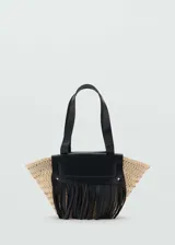 Bolso tipo cesta de fibra natural tejida, con solapa y flecos decorativos en cuero negro. Cuenta con doble asa corta de cuero.