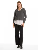 Buzo combinado marca Rio & Rian, con diseño de efecto capas que simula una camisa blanca debajo. Presenta un cuerpo de tejido de hilado fino en color beige con escote en V, y cuello y ruedo de gasa blanca.