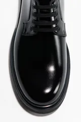 Zapatos Blucher negros de tejido revestido con acabado brillante, cordones abiertos, forro de lona de algodón y suela de goma con textura.