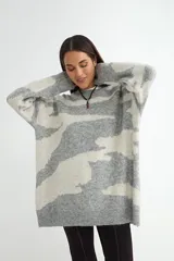 Buzo de punto con diseño estampado abstracto en blanco y negro, de corte holgado, cuello redondo y mangas largas con puños acanalados.