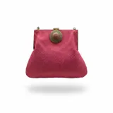 Bolso de yute color fucsia, tipo clutch, con broche metálico dorado opaco adornado con una piedra central. Incluye asa de cadena desmontable.