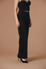 Pantalón negro de vestir de corte recto y tiro alto, con banda lateral de encaje tono sobre tono y apliques de brillo.
